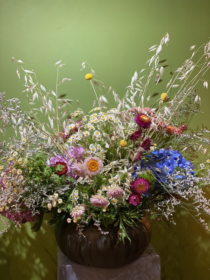Composizione campestre fiori di campo stile Boho Chic su vaso in terra cotta